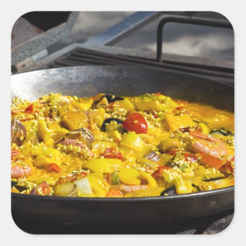 Paella is cooked on a grill square sticker