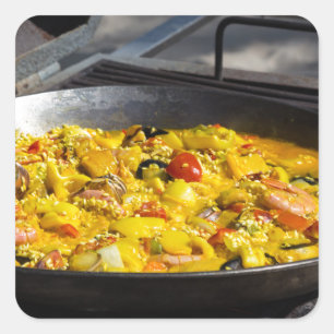 Paella is cooked on a grill square sticker