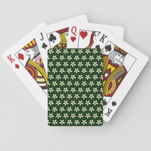 Pale green flower against dark green playing cards