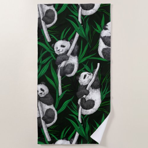 Panda cubs on dark green beach towel