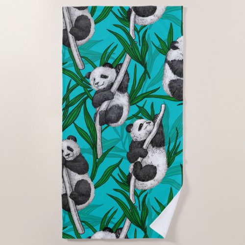 Panda cubs on turquoise beach towel