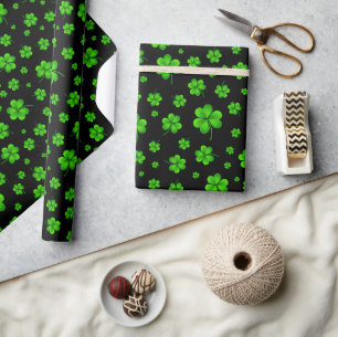 Pattern of green shamrocks on black background wrapping paper