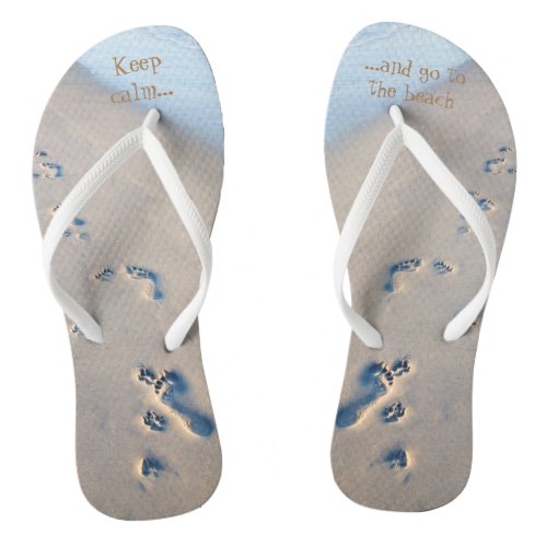 Paw prints and footprints in the sand flip flops