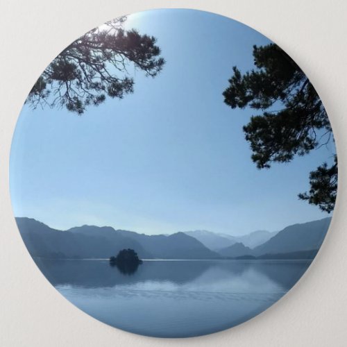 Peaceful blue lake with trees and blue sky button