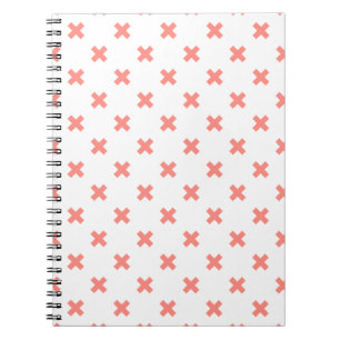 Peach cross stitches on white notebook