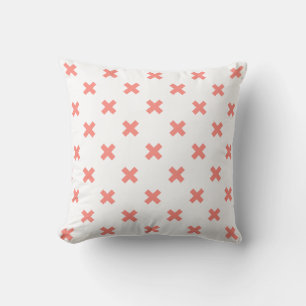 Peach cross stitches on white throw pillow
