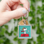 Peanuts | Snoopy the Flying Ace Keychain<br><div class="desc">This cute Peanuts design features Snoopy as the World War I flying ace reading to take on the Red Baron of Germany.</div>
