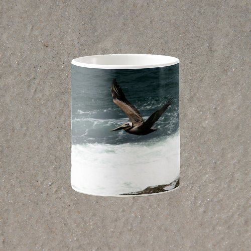 Pelican Flying Over Rocks and Ocean Photograph Coffee Mug