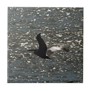 Pelican Flying Over Shimmering Lake Bafa Ceramic Tile