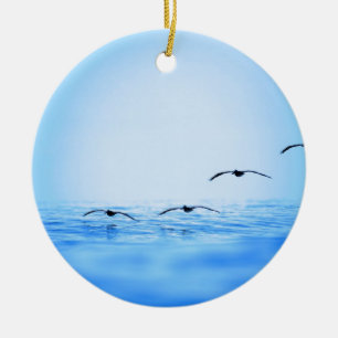 Pelicans flying over ocean ceramic ornament