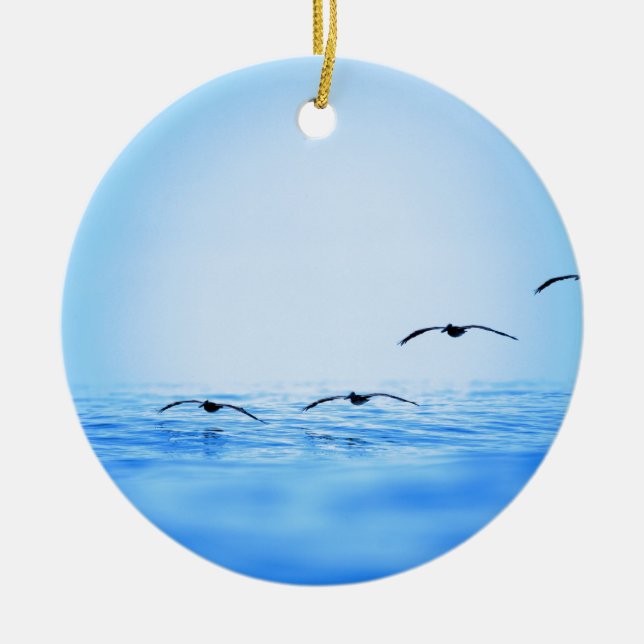 Pelicans flying over ocean ceramic ornament (Front)