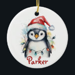 Penguin Personalized Christmas Ornament<br><div class="desc">Celebrate the season with this adorable personalized penguin Christmas ornament! Featuring a watercolor-style penguin wearing a Santa hat and wrapped in colorful holiday lights, this ceramic keepsake includes your child’s name in festive red script. A perfect addition to any Christmas tree, this ornament makes a sweet gift for kids, grandkids,...</div>