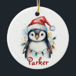 Penguin Personalized Christmas Ornament<br><div class="desc">Celebrate the season with this adorable personalized penguin Christmas ornament! Featuring a watercolor-style penguin wearing a Santa hat and wrapped in colorful holiday lights, this ceramic keepsake includes your child’s name in festive red script. A perfect addition to any Christmas tree, this ornament makes a sweet gift for kids, grandkids,...</div>