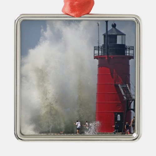 People on jetty watch large breaking waves in metal ornament