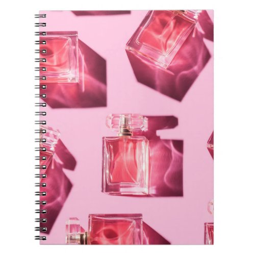 Perfume bottles pink background flatlay notebook