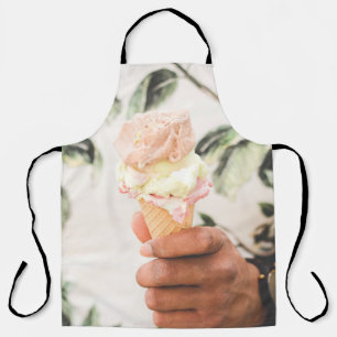 Person holding ice cream cone with three flavors o apron