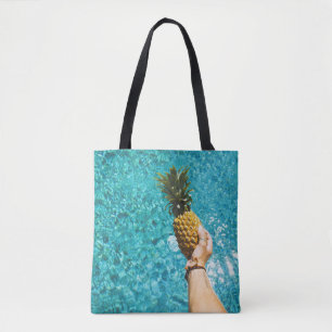 Person holding yellow pineapple tote bag