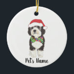 Personalized Bernedoodle Santa Hat & Bowtie Ceramic Ornament<br><div class="desc">I am in love with this beautifully detailed watercolor illustration of a grey, black, and white bernedoodle or sheepadoodle on a an ornament with a sweet little red and green bow tie and santa hat combo! Personalize these ornaments and make the nice list this year! For the perfect presents, pair...</div>