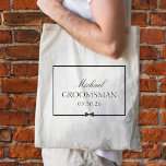 Personalized Classic Simple Bowtie Groomsman Tote Bag<br><div class="desc">Honor your groomsman with this sophisticated, customizable tote bag. Featuring a sleek black-and-white design, it highlights the groomsman’s name, title, and wedding date, framed by an elegant border and a stylish bow illustration. Ideal for carrying all the essentials on the big day, this tote blends seamlessly into any wedding theme,...</div>