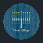 Personalized Family Name Blue Hanukkah Menorah Cutting Board<br><div class="desc">Celebrate Hanukkah with a modern twist using this deep blue design featuring a stylized menorah with glowing golden flames. The family name sits elegantly below in a refined serif font, adding a personal and festive touch. Perfect for holiday hosting, this design is ideal for families who value tradition, warmth, and...</div>