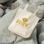 Personalized Graduate Class of 2024 Gold Tote Bag<br><div class="desc">Graduate Class of 2024 quote features a cap with tassel,  modern topography and calligraphy script,  accented with florals and hearts.  Easily personalize with your name of choice and monogram on back.  Great gift idea for that special grad.  (School Color: Gold)</div>