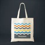 Personalized Kids Chevron Gray Blue Orange Yellow Tote Bag<br><div class="desc">Personalized Kids Chevron Gray Blue Orange Yellow Personalized Tote Bag. Classy and bright colors in multicolored chevron stripe with white between colors. Yellow,  orange,  blue and gray stripes. Personalize with name in white font on gray background.  Choose from a variety of styles and sizes.</div>