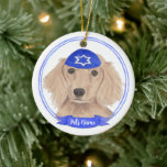 Personalized Red English Dachshund Dog Hanukkah Ceramic Ornament<br><div class="desc">Celebrate your favorite mensch on a bench with personalized ornament! This design features a sweet illustration of a red english long haired dachshund dog with a blue and white yarmulke. For the most thoughtful gifts, pair it with another item from my collection! To see more work and learn about this...</div>