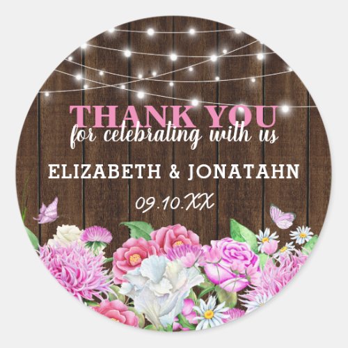 Personalized Rustic Pink Floral Wedding Classic Round Sticker - Country chic wedding stickers featuring a rustic wood background, backyard string lights, elegant pink and white garden watercolor flowers, and a wedding thank you template that is easy to personalize.