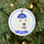 Personalized White Doodle Dog Hanukkah Ceramic Ornament<br><div class="desc">Celebrate your favorite mensch on a bench with personalized ornament! This design features a sweet illustration of a white doodle dog with a blue and white yarmulke. For the most thoughtful gifts, pair it with another item from my collection! To see more work and learn about this artist, visit her...</div>
