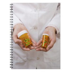 Pharmacist holding pill bottles notebook