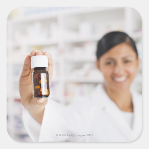 Pharmacist in drug store holding out pill bottle square sticker