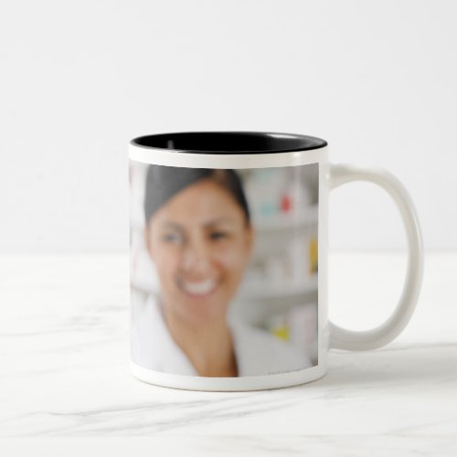 Pharmacist in drug store holding out pill bottle Two_Tone coffee mug