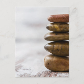 Pile of dark colored stones on white background postcard