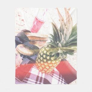 Pineapple beside phone and speaker fleece blanket