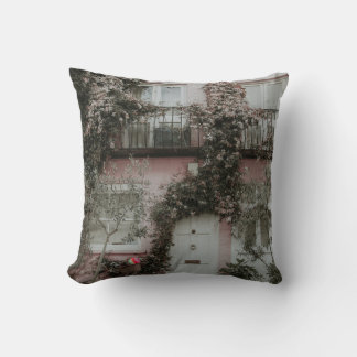 PINK AND WHITE PAINTED HOUSE COVERED WITH PLANTS A THROW PILLOW