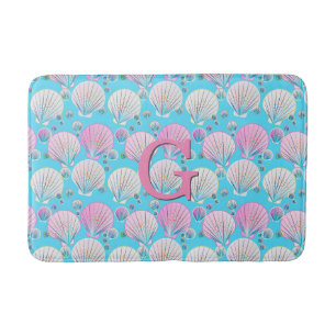 Pink and white sea shells on turquoise bathroom mat