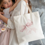 Pink Bow Tote Bag<br><div class="desc">Add a touch of elegance and femininity to your everyday style with this chic tote bag featuring a delicate pink bow and a personalized script initial monogram. The soft, girly design is perfect for a stylish accessory, adding a cute and trendy accent to any outfit. Easily customize with your initial...</div>