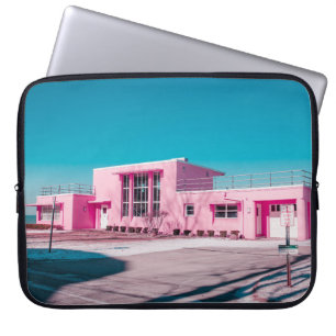 Pink concrete building under clear blue sky laptop sleeve