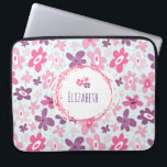 Pink Flowers and Blue Hearts Cute Whimsical Laptop Sleeve<br><div class="desc">Laptop sleeve with a cute floral pattern. Composed of pink and purple irregular shaped flowers in a retro sixties groovy style. Faint faded little blue hearts, pepper the background on a pale blue backdrop. A white circle with a cute pink border with dots and splatters with your name or other...</div>