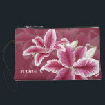 Pink Lillies Suede Wristlet<br><div class="desc">A ruby background color with painted stargazer lillies in shades of pink, red, and white. Add your name to the text field or clear it out if wish. You can also click on "Customize It!" to adjust the font type, size, color, placement, etc. Artwork and design by Karlajkitty.</div>