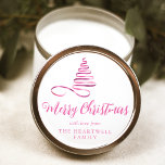 Pink Ribbon Tree Merry Christmas Script Classic Round Sticker<br><div class="desc">This modern holiday sticker features a shiny pink ribbon in the shape of a Christmas tree and the words "Merry Christmas" in stylish pink calligraphy script. Personalize it with your family's name in serif font.</div>