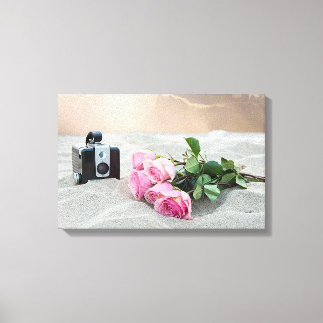 pink roses in sand with retro camera canvas print (Front)