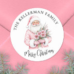 Pink Santa Merry Christmas Classic Round Sticker<br><div class="desc">Add a festive and feminine touch to your holiday gifts with this round Christmas sticker featuring a stylish watercolor Santa Claus in the center. Santa is dressed in a soft pink coat and matching hat, holding a bouquet of pink poinsettias, holly berries, and pine sprigs—adding a whimsical and fashion-forward feel...</div>