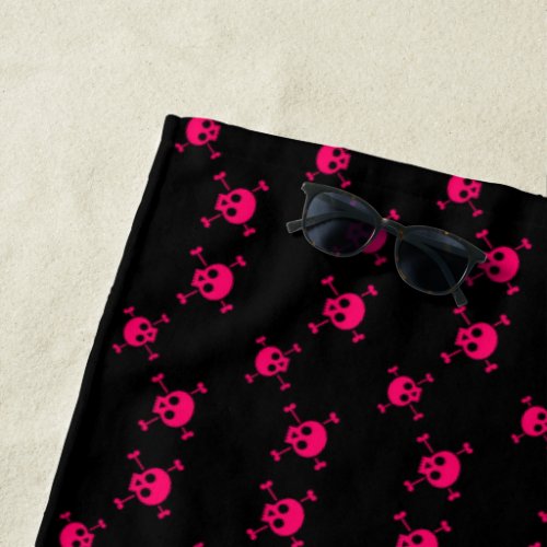 Pink skull and crossbones on black beach towel