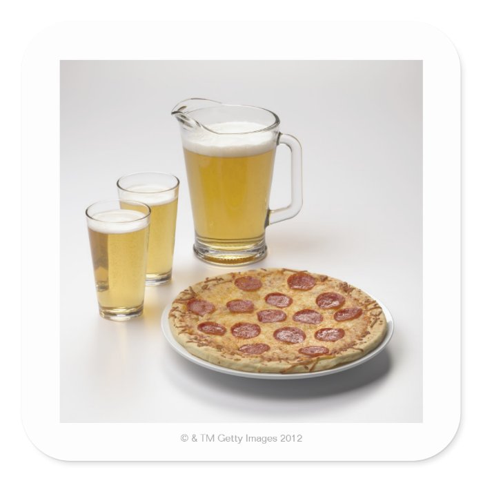 Pitcher and two pints of beer beside pepperoni stickers