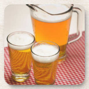 Pitcher of beer and two glasses filled with beer coaster
