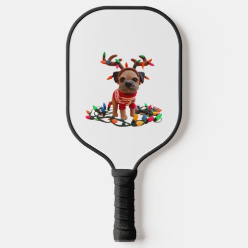 Playful Border Terrier helping with the Christmas  Pickleball Paddle