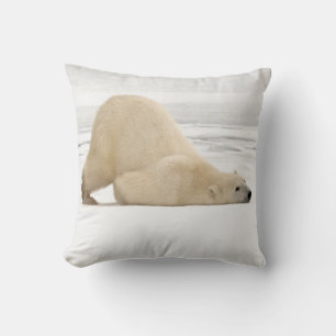 Polar bear scratching itself on frozen tundra throw pillow