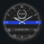 Police Styled American Flag Badge and Name Large Clock<br><div class="desc">A wall clock featuring a thin blue line American flag symbolic of law-enforcement.  Roman numerals and a spot for yours or your gift recipient's badge number and last name.</div>