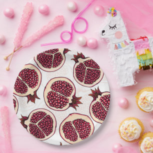 Pomegranate slices on white paper plates